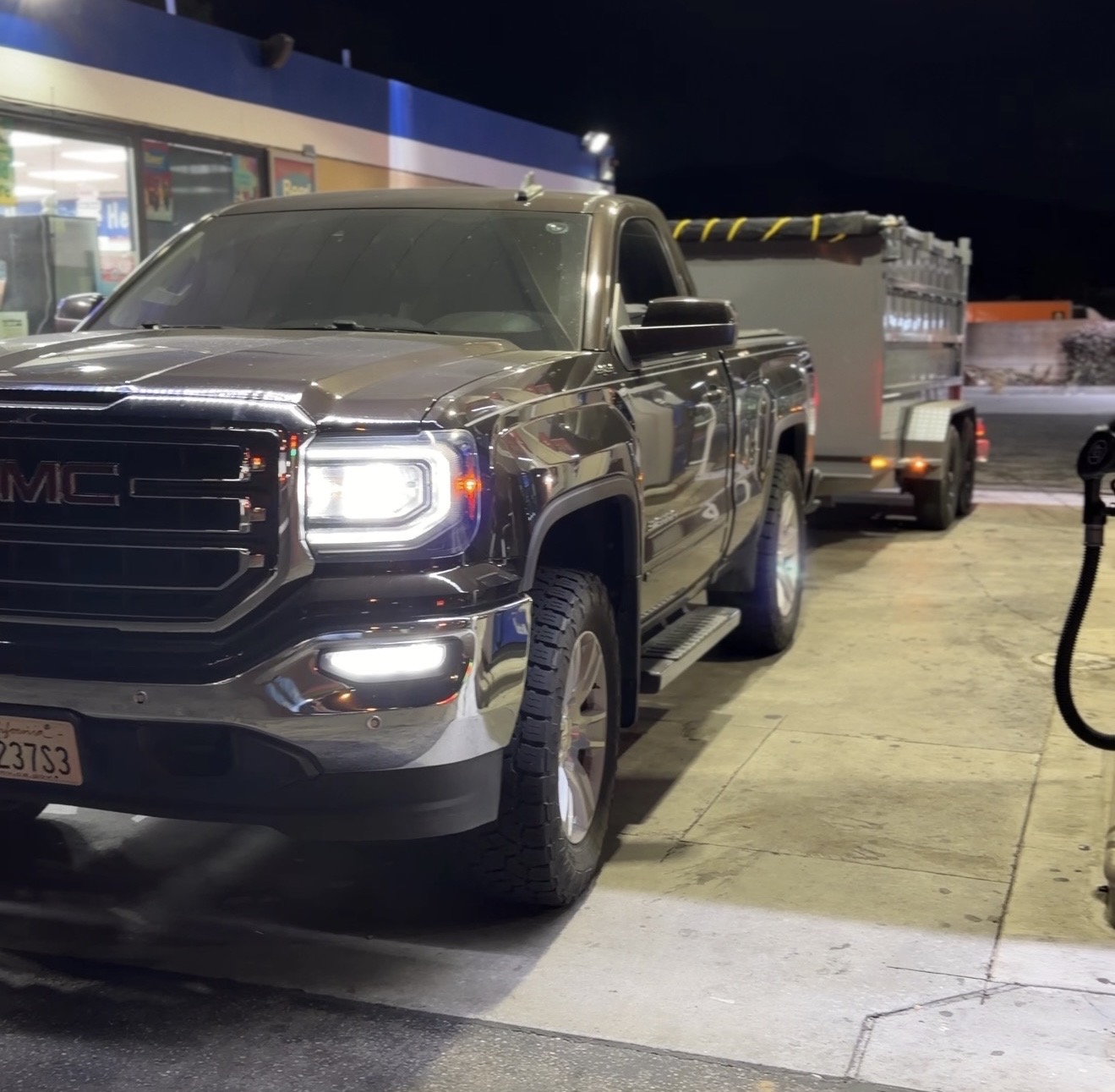 LR Transport truck towing an enclosed trailer at night